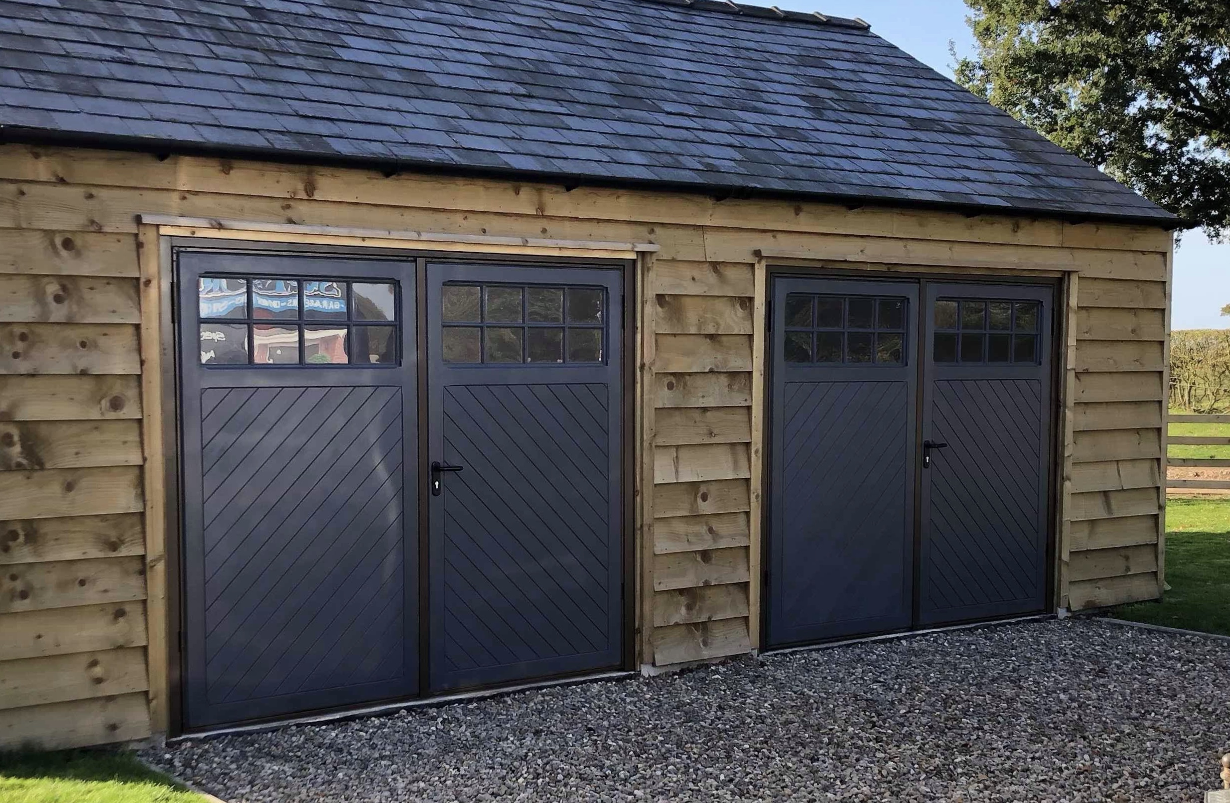 Two pairs of side hinged doors with glazing on a timber garage